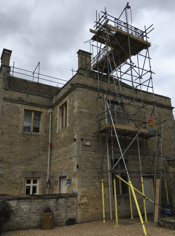 Scaffolding access tower with roof edge protection handrail.